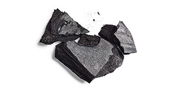 Large fragments of activated charcoal against a white background.