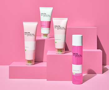 The Botanical Effects skin care set in white and pink tubes on a pink background