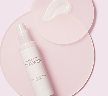 Uncapped bottle of Mary Kay TimeWise Tone-Correcting Serum and product rub on separate clear discs