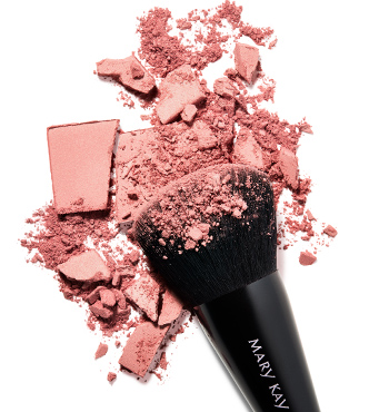 The Mary Kay cheek brush lying in a pile of artfully crushed pink blush