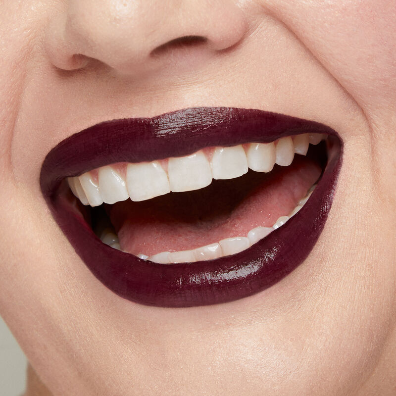 Close up of fair skinned model&rsquo;s smiling lips wearing Mary Kay Supreme Hydrating Lipstick in shade Black Cherry.