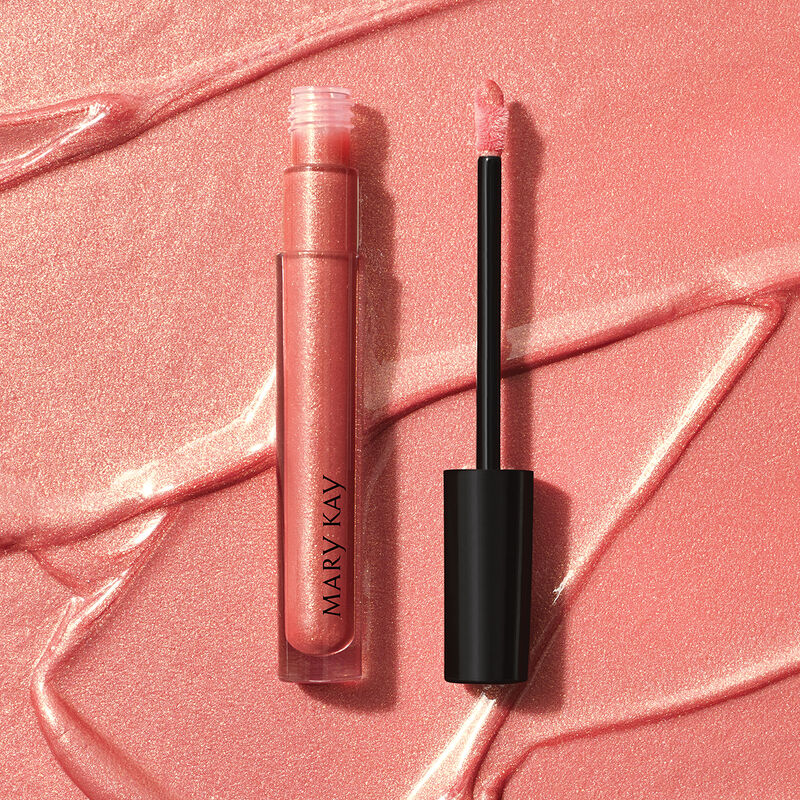 Open tube of Mary Kay Unlimited Lip Gloss in shade Fancy Nancy against accompanying shade rub