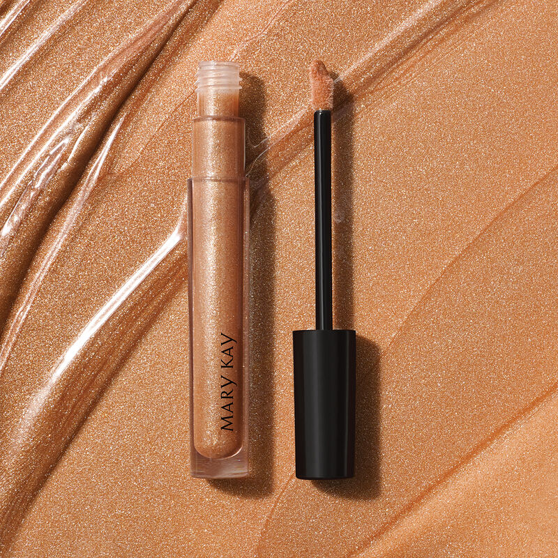 Open tube of Mary Kay Unlimited Lip Gloss in shade Beach Bronze against accompanying shade rub