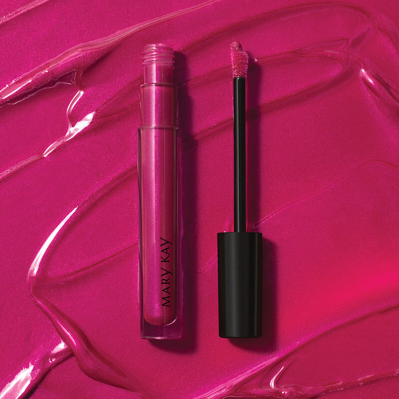 Open tube of Mary Kay Unlimited Lip Gloss in shade Berry Delight against accompanying shade rub