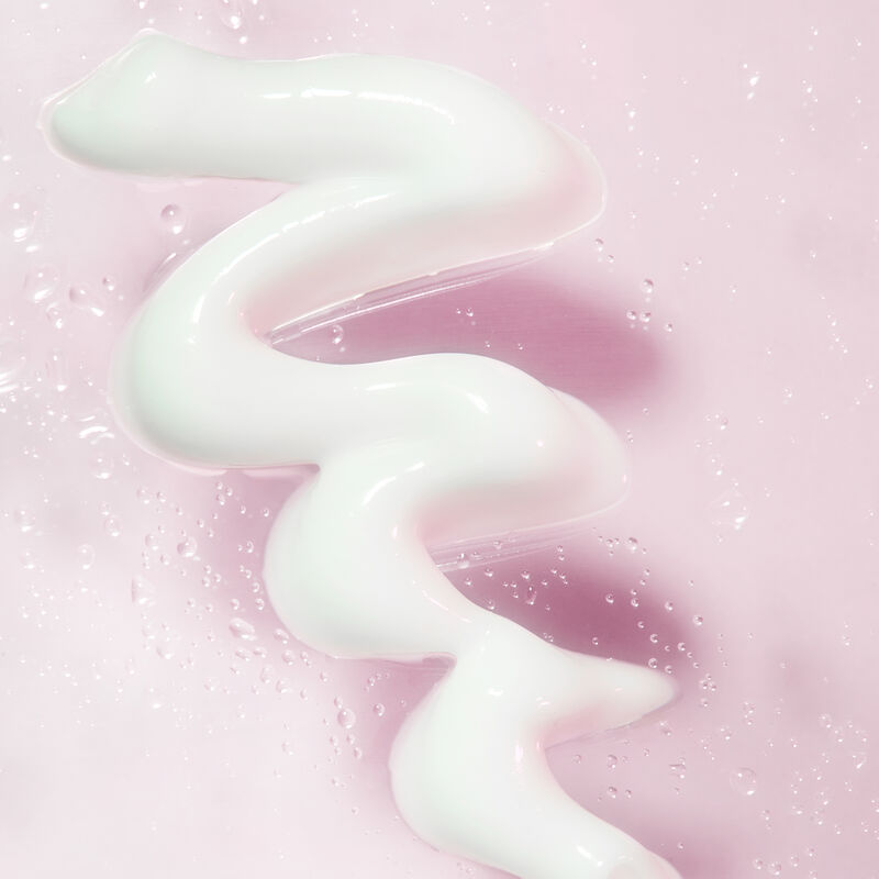Product rub of Mary Kay Hydrating Moisturizer amidst water droplets against light pink background