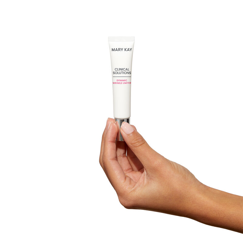 Mediumskinned hand holding tube of Mary Kay Clinical Solutions Dynamic Wrinkle Limiter against a plain background