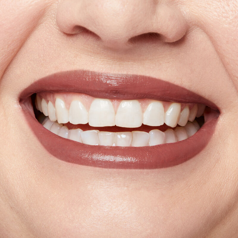 Close up of fair skinned model&rsquo;s smiling lips wearing Mary Kay Supreme Hydrating Lipstick in shade Hushed Blush.