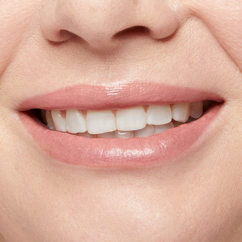 Close up of fair skinned model&rsquo;s smiling lips wearing Mary Kay Supreme Hydrating Lipstick in shade Natural.