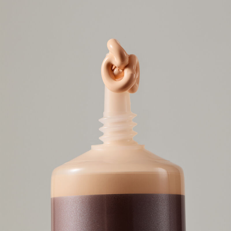 "Macro view of TimeWise Luminous 3D Foundation needle-nose applicator dispensing Light 1 shade"