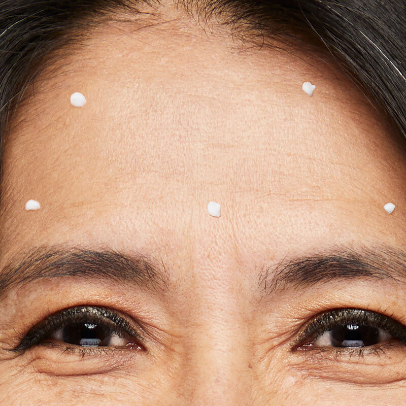 Closeup image of Dynamic Wrinkle Limiter placed in dots throughout forehead of mature brunette woman with smiling eyes