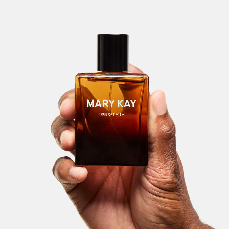 Mary Kay True Optimism Eau de Parfum surrounded by fragrance note ingredients, against stone background 