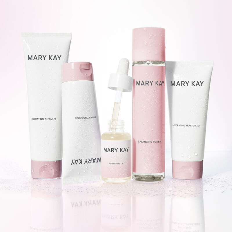 Produits de soins de la peau Mary Kay avec une bouteille ouverte de l&rsquo;Huile nourrissante Mary Kay debout sur une surface r&eacute;fl&eacute;chissante.&nbsp;&nbsp;