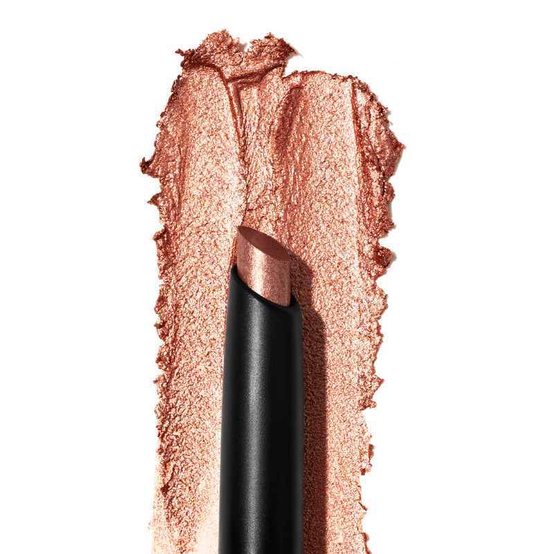 A product rub showing off the Copper Nova shade, finish and texture appears on a white surface with the uncapped product in front of it.