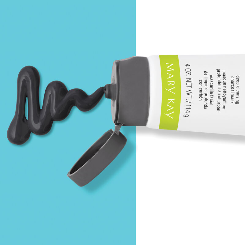 The Mary Kay Clear Proof Deep Cleansing Charcoal Mask pours out of its bottle and rests atop a turquoise blue background