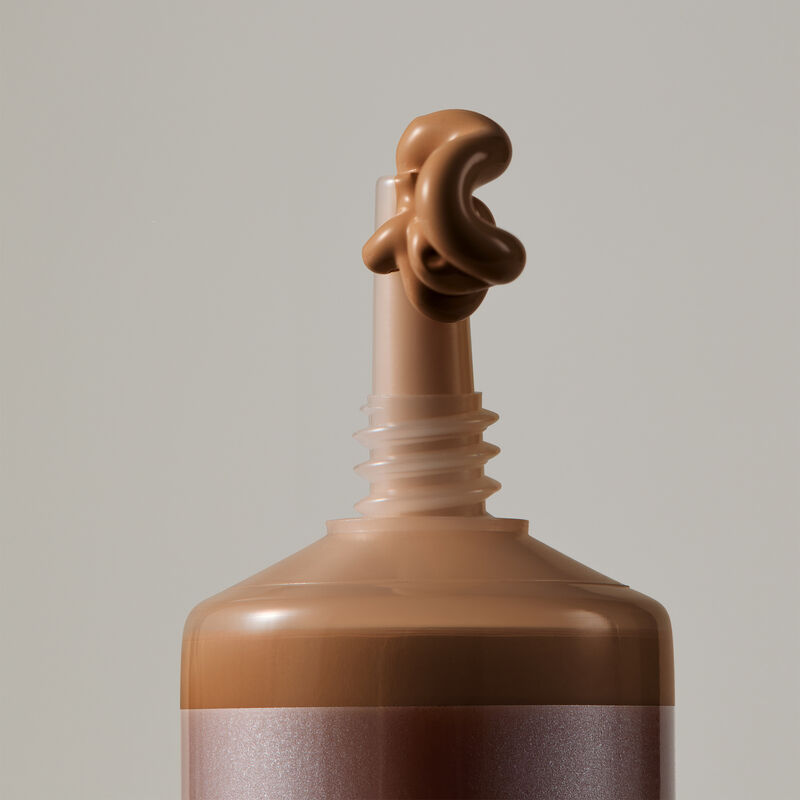 Macro view of TimeWise Luminous 3D Foundation needle-nose applicator dispensing Deep 6 shade
