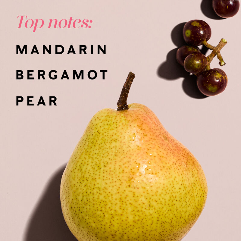 A pear lies on a light pink background