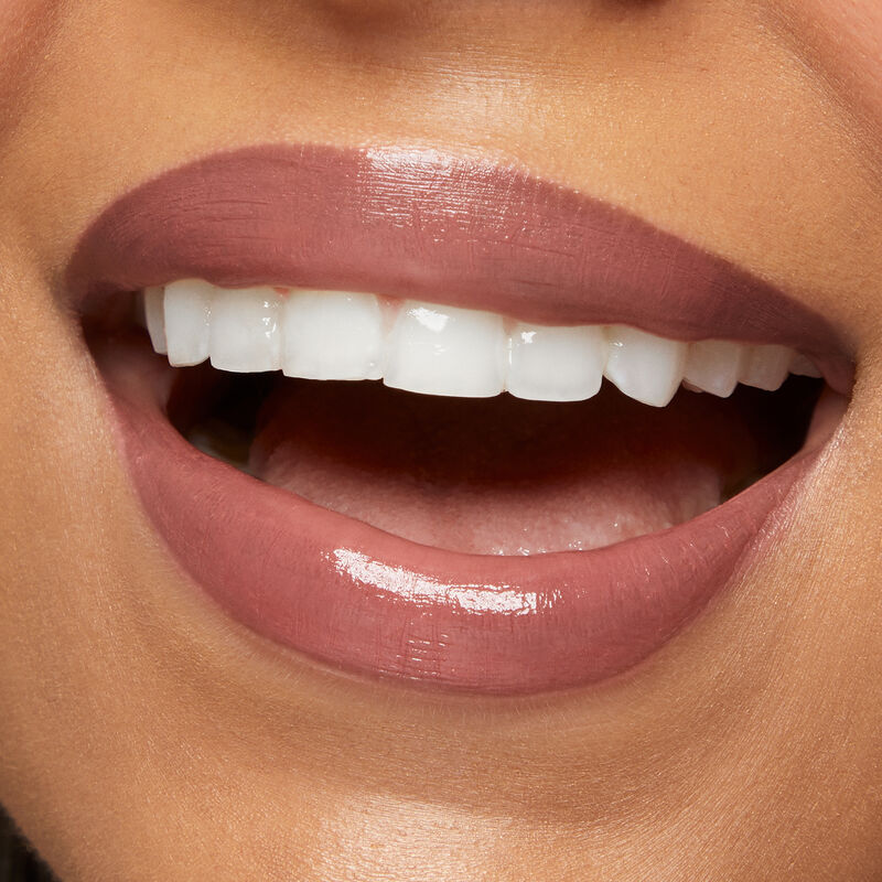 Close up of medium skinned model&rsquo;s smiling lips wearing Mary Kay Supreme Hydrating Lipstick in shade Hushed Blush.