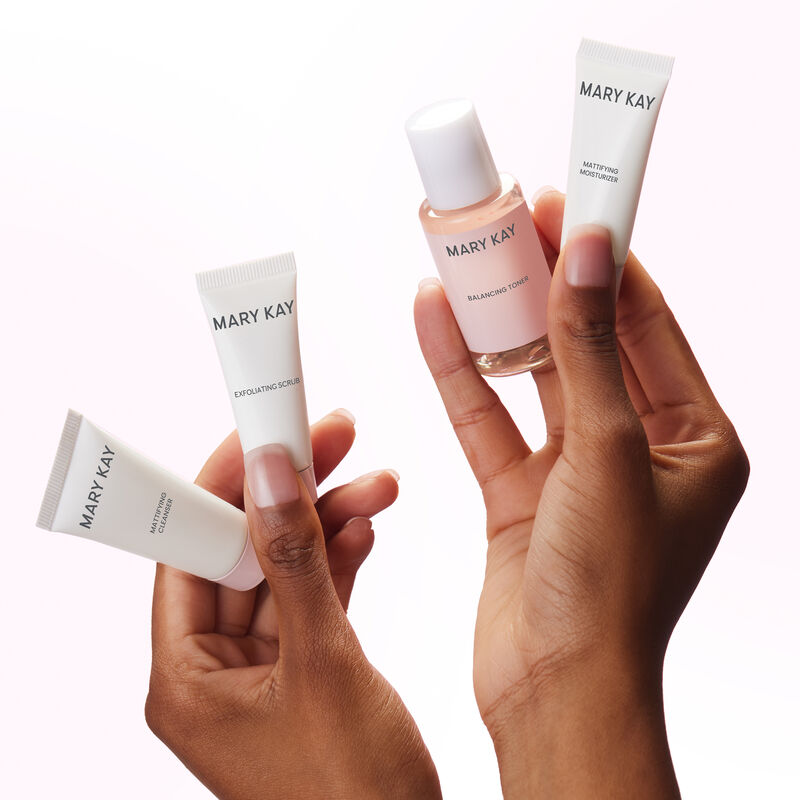 Pair of hands holding all four products in the Mary Kay Skin Care Mattifying Go Set