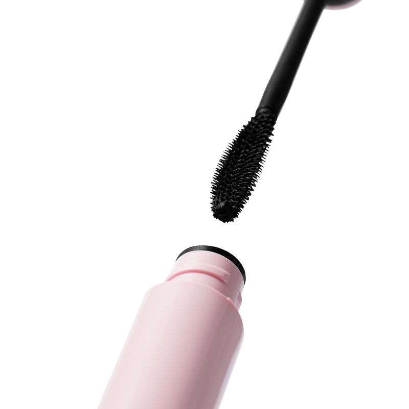 Curved brush with black mascara descending to open pink tube of Mary Kay&reg; Great Heights&trade; Mascara
