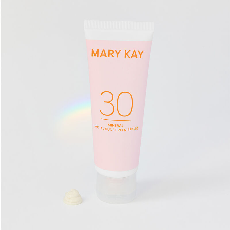 Model dispensing Mary Kay Mineral Facial Sunscreen onto finger