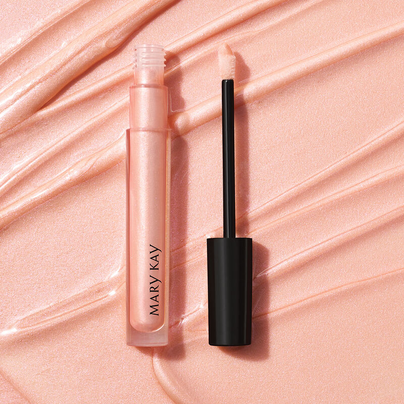 Open tube of Mary Kay Unlimited Lip Gloss in shade Sheer Illusion against accompanying shade rub