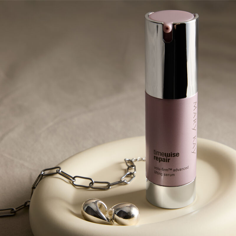 Advanced Lifting Serum standing in a dish with a silver bracelet and earrings
