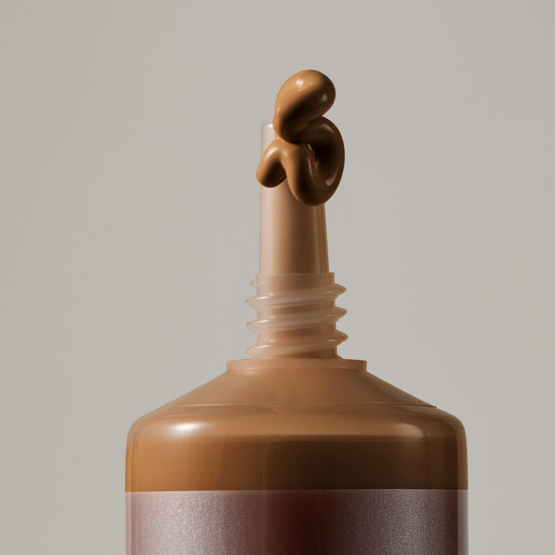 Macro view of TimeWise Luminous 3D Foundation needle-nose applicator dispensing Deep 3 shade