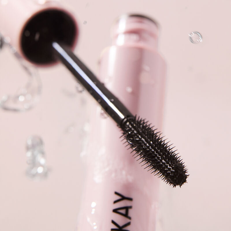 Close-up hero image of Mary Kay Great Heights Waterproof Mascara with tube open and wand positioned in front of it styled with water droplets