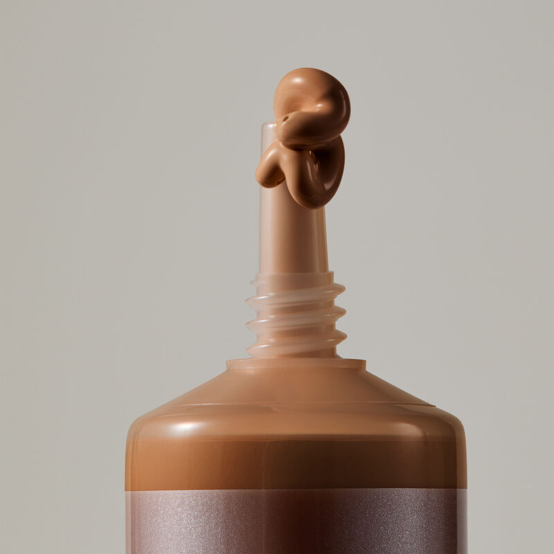 Macro view of TimeWise Matte 3D Foundation needle-nose applicator dispensing Deep 4 shade