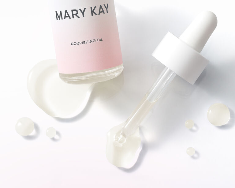 Bottle of Mary Kay Nourishing Oil next to a dropper with oil coming out 