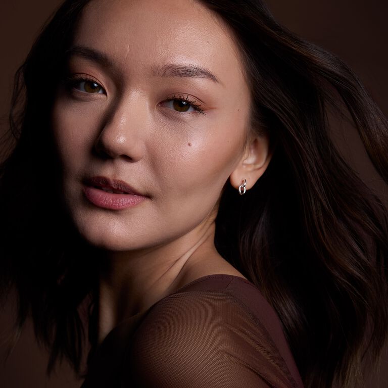 Brunette model applying brown eyeliner