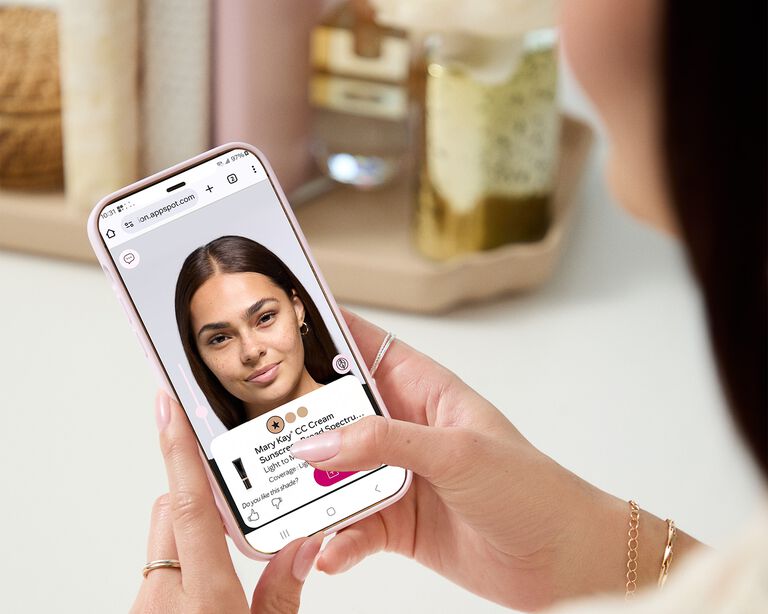 Des mains tiennent un appareil mobile montrant l&rsquo;Outil de s&eacute;lection de fond de teint Mary Kay.