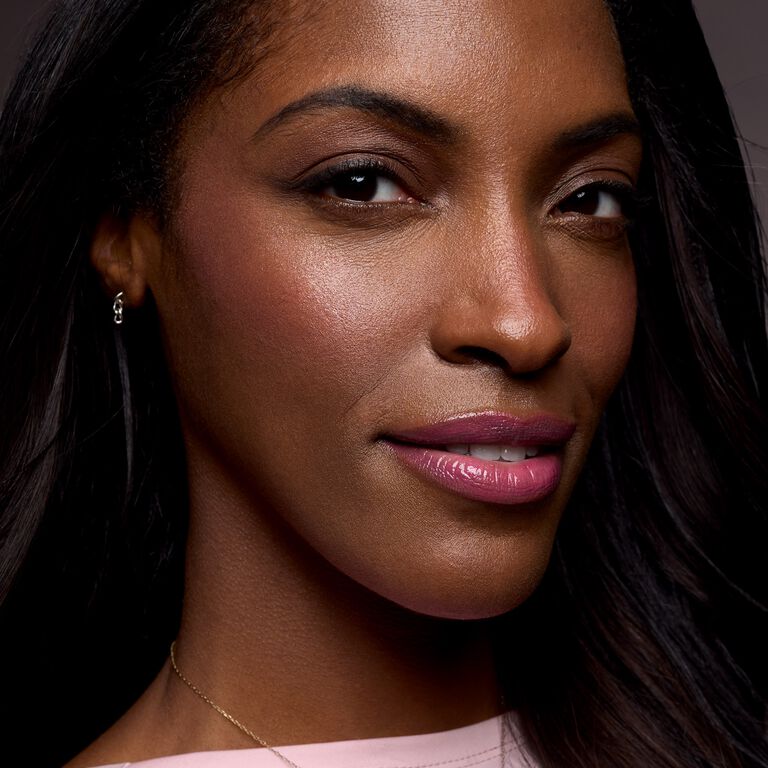 Model with glossy pink lips and lifted cheeks