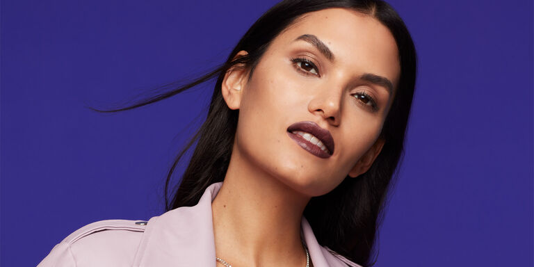 Woman wearing deep shade of Mary Kay Supreme Hydrating Lipstick looks at the camera.