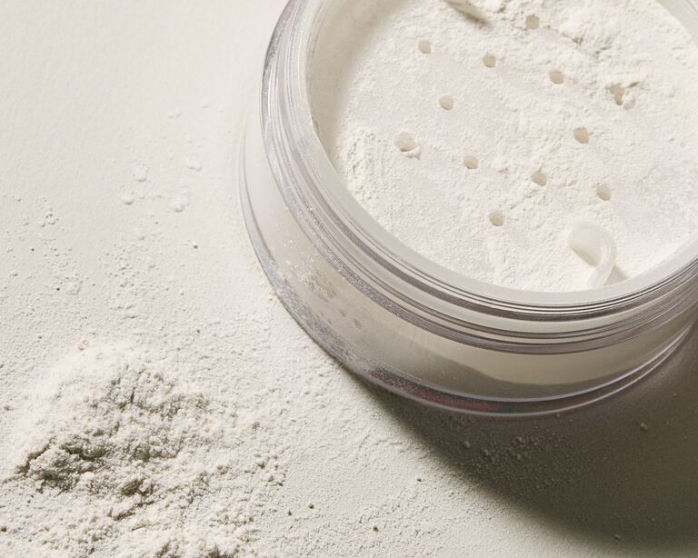 Close-up of an open container next to a pile of white powder