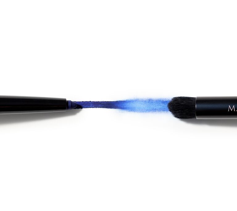 Blue eyeliner swipe between an eyeliner pencil and a makeup brush 