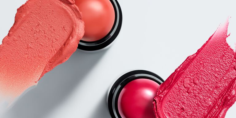 Two blush sticks with a coordinating product smudge above each shade