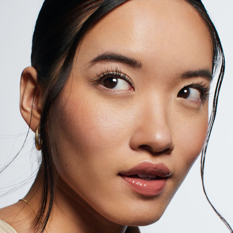 Model looking to the side, wearing makeup applied using the underpainting technique.