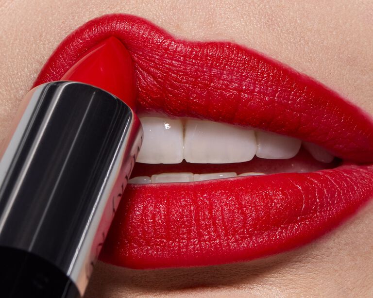 Close-up of red lipstick being applied to lips