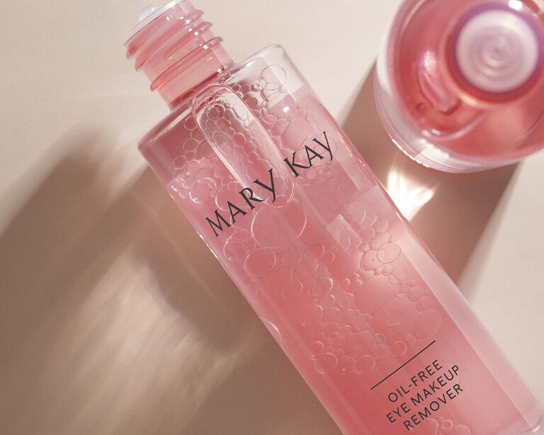 Two pink bottles of eye makeup remover against a light background
