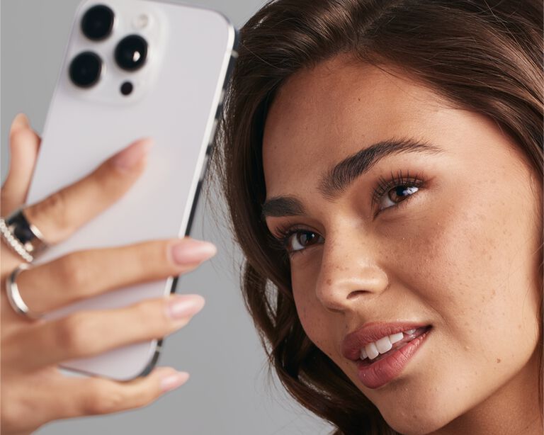 Une femme fait l&rsquo;essai de l&rsquo;outil de s&eacute;lection de fond de teint sur son t&eacute;l&eacute;phone.