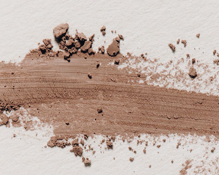 Product swatch featuring dark brown eye shadow powder