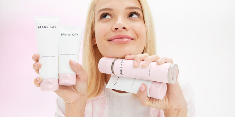 Mannequin blonde tenant les 4 produits de la gamme de Soins de la peau Mary Kay
