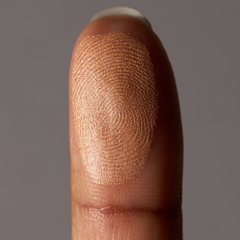 Close-up of a fingertip covered in shimmery powder