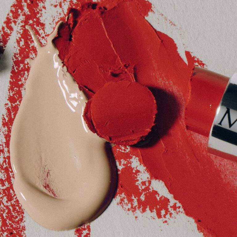 Product swatch featuring red lipstick and cream concealer