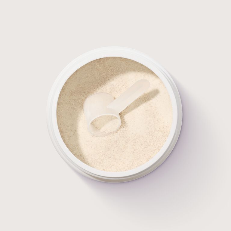 Open container of Mary Kay Collagen powder with a scoop resting on top, viewed from above against a plain background.