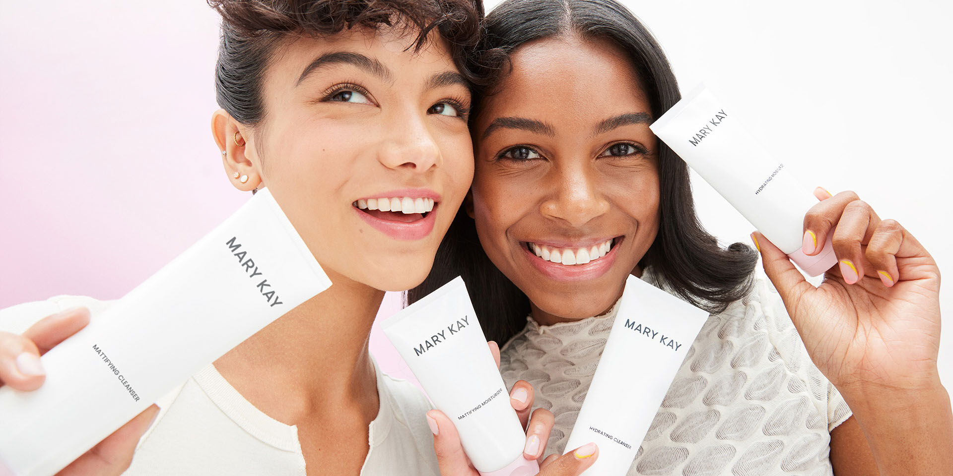 Deux mannequins tenant des produits de la gamme de Soins pour la peau Mary Kay et souriant