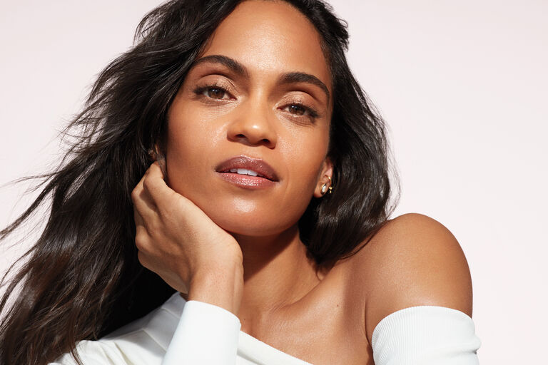 Woman with chin resting on hand with glowing skin