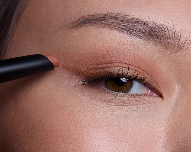 Close-up of a brown eye with winged eyeliner being applied