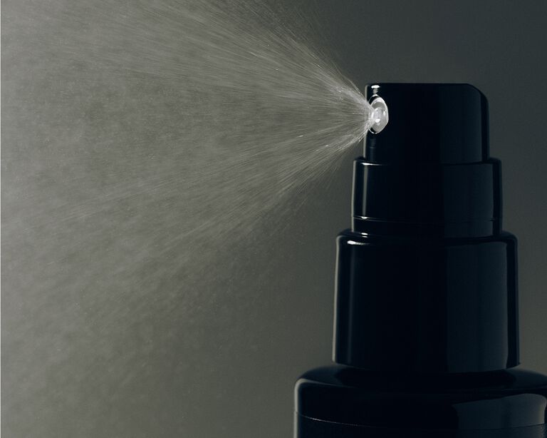 Close-up of a finishing spray bottle releasing a fine mist